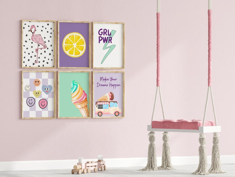 May include: Five framed prints with various designs, including a flamingo, a lemon, a lightning bolt, ice cream, and a smiley face. The prints are hanging on a pink wall with a white swing hanging in front of them.