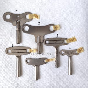 May include: Six different clock winding keys, each with a unique shape and size. The keys are made of metal and have a silver finish. The keys are labeled with numbers 1 through 6.