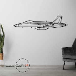 以下が含まれることがあります： 戦闘機の黒い金属製の壁飾り。グレーの肘掛け椅子と床置き照明が背景にある。