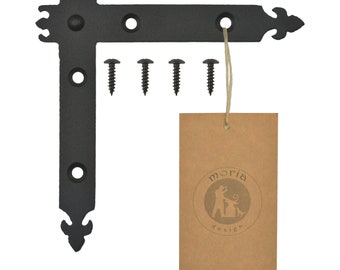 May include: Black metal corner brace with decorative fleur-de-lis accents. The brace has four screw holes and comes with five black screws. The brace is labeled with a brown tag that reads "moria design".
