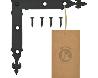 May include: Black metal corner brace with decorative fleur-de-lis accents. The brace has four pre-drilled holes for mounting. It comes with four black screws. The brace is labeled with the Moria Design logo.