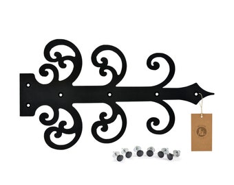 May include: Black metal hinge with ornate scrollwork design. The hinge is attached to a brown paper tag with the word "Wisteria" and a small logo. The hinge is accompanied by eight black screws.