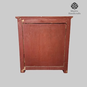May include: A red wooden cabinet with a single door. The cabinet has a simple design and is made of solid wood.
