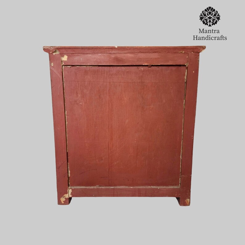 May include: A red wooden cabinet with a single door. The cabinet has a simple design and is made of solid wood.