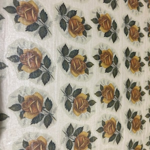 Könnte beinhalten: Ein Blatt Geschenkpapier mit einem sich wiederholenden Muster aus braunen Rosen mit grünen Blättern auf weißem Hintergrund.