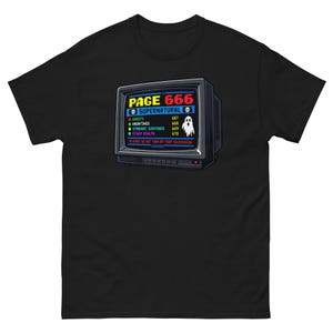 Può includere: Una t-shirt nera a maniche corte con la grafica di un vecchio schermo televisivo che mostra il testo PAGE 666 SUPERNATURAL, un elenco di categorie tra cui GHOSTS, HAUNTINGS, STRANGE SIGHTINGS, OTHER REALMS e PLEASE DO NOT TURN OFF YOUR TELEVISION.