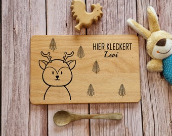 May include: A wooden plate with a deer design and the text "HIER KLECKERT Levi" engraved on it. The plate is surrounded by small tree designs.