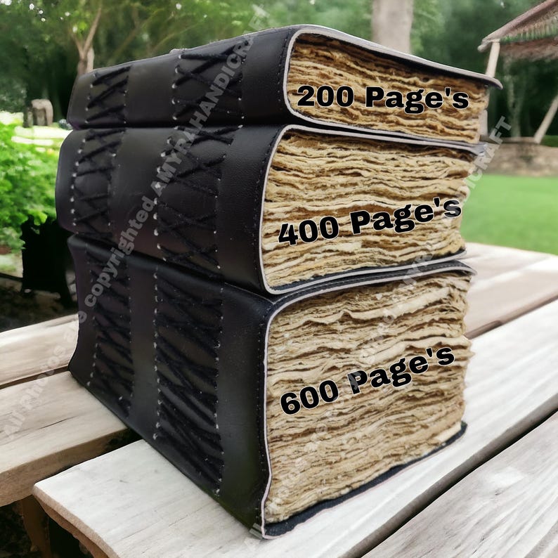 May include: Three stacked black leather journals with stitched detailing. The journals have aged, cream-coloured pages. Text on the journals reads "200 Page's", "400 Page's", and "600 Page's".