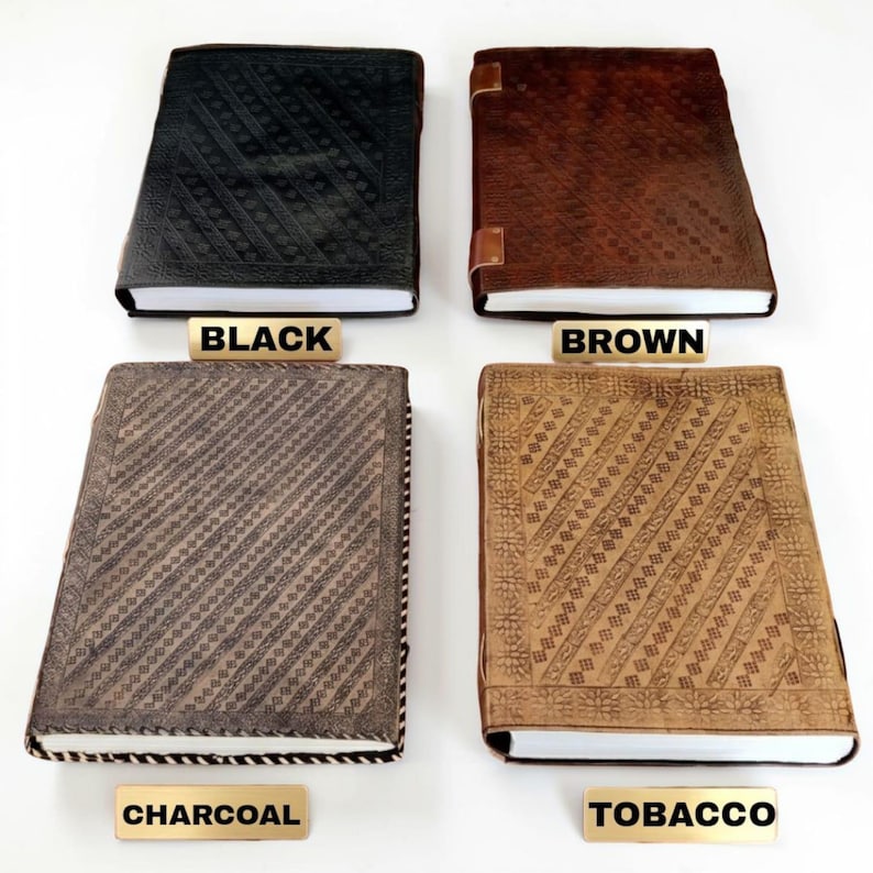May include: Four leather-bound journals in black, brown, charcoal, and tobacco colours. Each journal has a unique embossed pattern on the cover. The text labels below each journal read "BLACK", "BROWN", "CHARCOAL", and "TOBACCO".