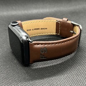 Könnte beinhalten: Ein braunes Lederarmband für die Apple Watch mit dem eingravierten Text "Ich Liebe Dich".
