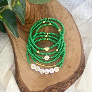 May include: A white ceramic mug with a black handle and the text "But First, Coffee" in a bold, black font. The mug is set against a blurred background, suggesting a cozy setting.