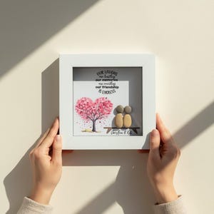 May include: A framed artwork with a white border. The artwork features a pink heart-shaped tree, two pebble figures, and the text "Our laughs are limitless, our memories are countless, our friendship is endless."