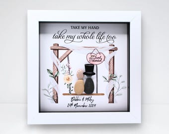 May include: A framed artwork featuring pebble art of a couple under a wooden arch with the text "Take my hand, take my whole life too." A "Just Married" sign hangs above the couple. The date "24th November 2024" is also included.