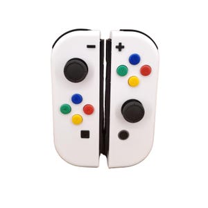 May include: A white Nintendo Switch Joy-Con controller with colourful buttons. The controller is split in half, with the left side showing the minus button and the right side showing the plus button.