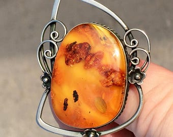 Broche vintage de ámbar báltico: marco metálico floral, ámbar color caramelo