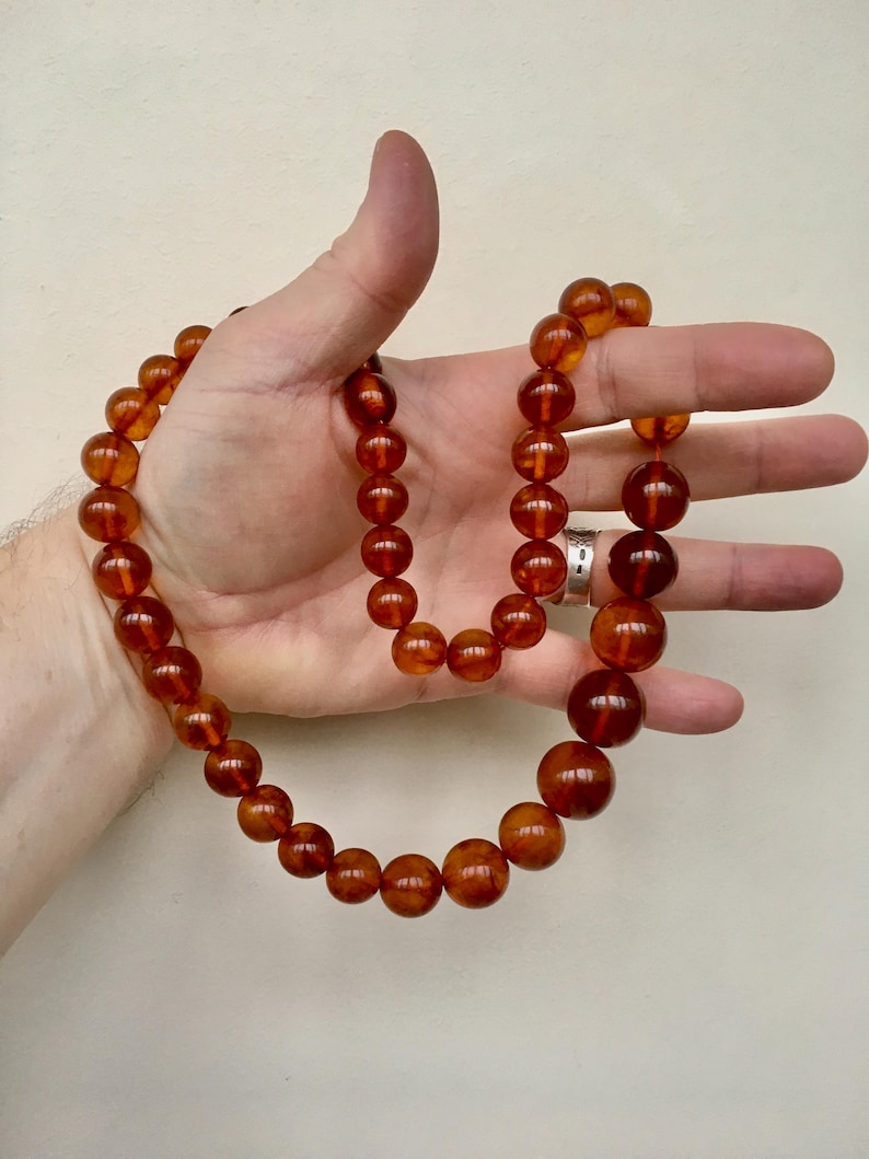 Puede incluir: Un collar largo de &aacute;mbar con cuentas redondas. El collar est&aacute; hecho de &aacute;mbar natural y tiene un color c&aacute;lido, similar al de la miel.