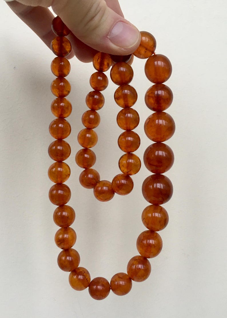 Puede incluir: Un collar largo de &aacute;mbar con cuentas redondas. El collar est&aacute; hecho de &aacute;mbar natural y tiene un color c&aacute;lido, similar al de la miel.