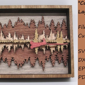 Peut inclure: Une scène en bois en couches représentant un canoë dans une forêt avec un reflet en miroir. La scène est encadrée en bois et comprend le texte "Canoe Mirror" et "Layered Scene". Des fichiers pour la découpe au laser sont disponibles aux formats SVG, DXF, EPS et PDF.