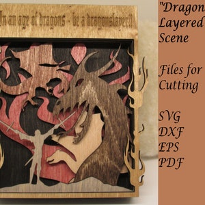May include: A wooden layered scene of a dragon slayer fighting two dragons. The scene is framed in wood with the text "In an age of dragons - be a dragonslayer!" at the top. The text "Dragonslayer" is written in a larger font on the right side of the image. The text "Layered Scene" is written below "Dragonslayer". The text "Files for Laser Cutting" is written below "Layered Scene". The text "SVG, DXF, EPS, PDF" is written below "Files for Laser Cutting".