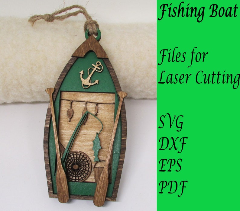 May include: A wooden ornament shaped like a fishing boat with green and brown paint. The boat has a fishing rod, a net, and a fish inside. The ornament has a rope for hanging and the text "Fishing Boat" and "Files for Laser Cutting" on the right side of the image. The text "SVG, DXF, EPS, PDF" is also visible.