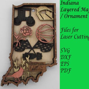 May include: A layered wooden map of Indiana with various icons representing the state's culture, including a basketball, a race car, a flower, and a cornfield. The map is designed for laser cutting and comes in SVG, DXF, EPS, and PDF formats. Files for Laser Cutting.