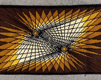 May include: A brown, yellow, and white geometric rug with a starburst pattern. The rug has a black border.
