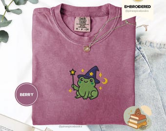 ウィザードフロッグTシャツ、刺繍入りフロッグウィザードTシャツ、マジカルコンフォートカラーズ1717、かわいいコテージコアシャツ、気まぐれなカエルのギフト、心地よいファンタジーTシャツ