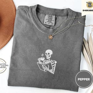 Embroidered Skeleton Reading a Book Shirt – Comfort Colors Book Lover Tee Cozy Aesthetic Embroidery Dark Academia Spooky Season Reader Shirt