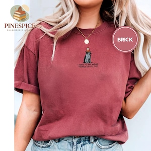 May include: A white ceramic mug with a black handle and the text "But first, coffee" in a handwritten style. The mug is on a white surface. The mug is approximately 4 inches tall.