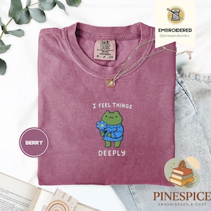 Può includere: Una tazza di ceramica bianca con manico nero e la scritta "But First, Coffee" in nero, in grassetto. La tazza è su una superficie bianca.
