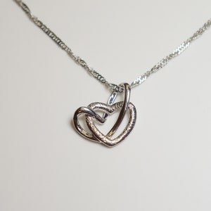 Exquisite sterling silver necklace, twin heart pendant, romantic jewelry, love-inspired accessory, dual heart charm keepsake.