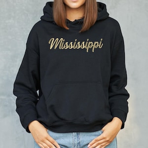 May include: Black hooded sweatshirt with a gold embroidered word "Mississippi" on the front.