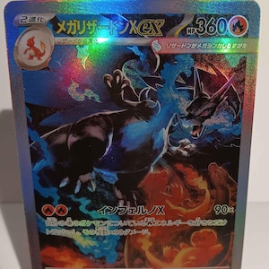 May include: A holographic trading card featuring a black and blue dragon-like creature with fiery accents. The card has Japanese text and a HP of 360. The card is displayed on a white stand.