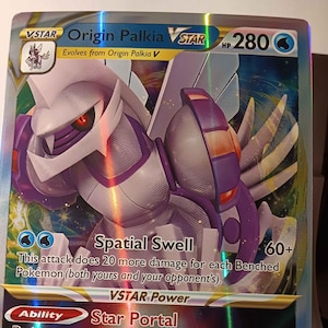 May include: Origin Palkia VSTAR Pokemon card with a holographic finish. The card features a purple and white Pokemon with blue eyes. The card has a HP of 280 and an attack called Spatial Swell. The card also has an ability called Star Portal.