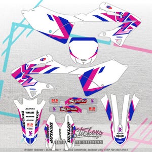 Könnte beinhalten: Eine Sammlung weißer Motorradaufkleber mit rosa und blauen geometrischen Designs. Die Aufkleber enthalten Markennamen wie Dunlop, Acerbis und Yamalube. Der Text "Stickers" ist ebenfalls sichtbar.