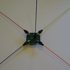 May include: A green circuit board with five wires attached. The wires are red, blue, yellow, orange, and purple. The wires are connected to the circuit board with black connectors.