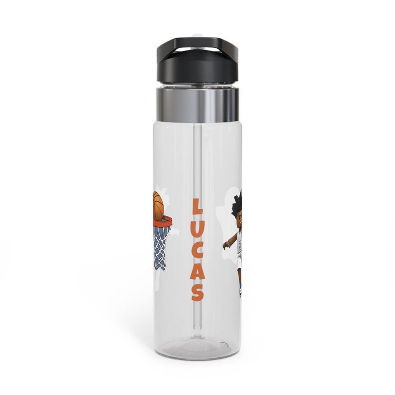 May include: A clear plastic water bottle with a black lid and a silver band around the middle. The bottle has a straw and a basketball themed design with the name "LUCAS" printed on the side.