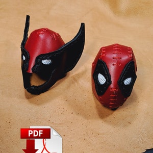 May include: Two red leather superhero masks, one with black ears and one with a black and white design. The masks are on a brown leather background. PDF Adobe.