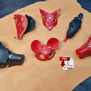 May include: A collection of five leather animal-themed masks and accessories in red and black. The set includes a black dog-style mask, a red mouse-style mask, a red fox-style mask, a black elongated accessory, and a red animal-shaped piece.