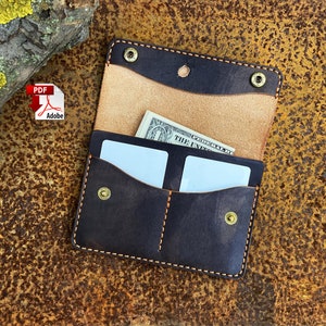 May include: A dark brown leather wallet with two card slots and a billfold. The wallet has a light brown leather interior and is closed with a snap.
