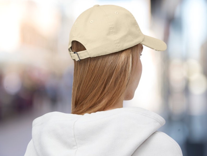 K&ouml;nnte beinhalten: Eine einfarbige, hellbeige Baseballkappe mit einem gebogenen Schirm. Die Kappe ist aus weichem Baumwollstoff gefertigt und hat einen verstellbaren Riemen hinten.