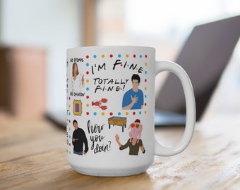 May include: White ceramic mug with a colorful design featuring characters and quotes from the TV show "Friends". The design includes the phrases "I'm Fine", "Totally Fine", and "How You Doin?" along with images of the characters.