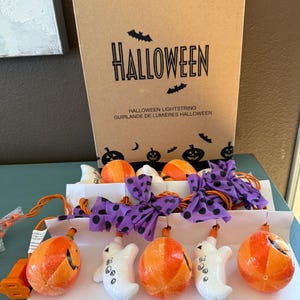 May include: A white ceramic mug with a black handle and the text "But First, Coffee" in a black, handwritten-style font. The mug is on a white surface.