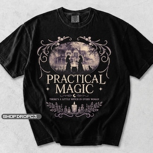 May include: A black t-shirt featuring a graphic print of a house, two figures, and a cauldron. The text reads PRACTICAL MAGIC and THERE'S A LITTLE WITCH IN EVERY WOMAN, accompanied by illustrations of a candle, bottles, and decorative floral vines.