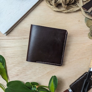 Cartera de cuero hecha a mano. Tiene capacidad para entre 6 y 12 tarjetas y billetes. Se puede personalizar con cualquier nombre, iniciales o grabado de imagen.