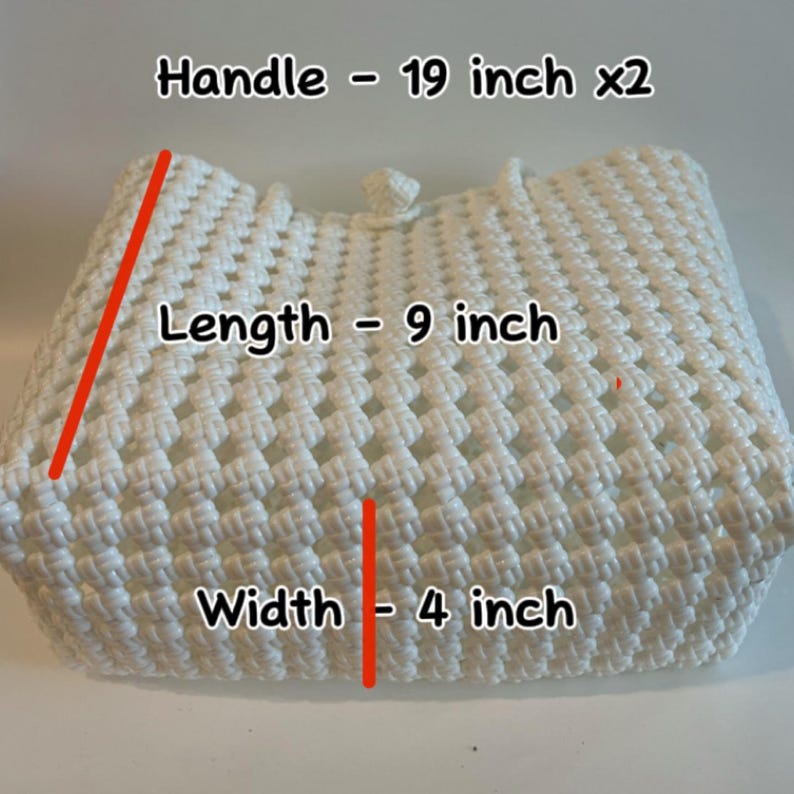 Może przedstawiać: Biała torba na zakupy wykonana na szydełku z dwoma uchwytami. Torba ma 23 cm długości, 10 cm szerokości, a uchwyty mają 48 cm długości.