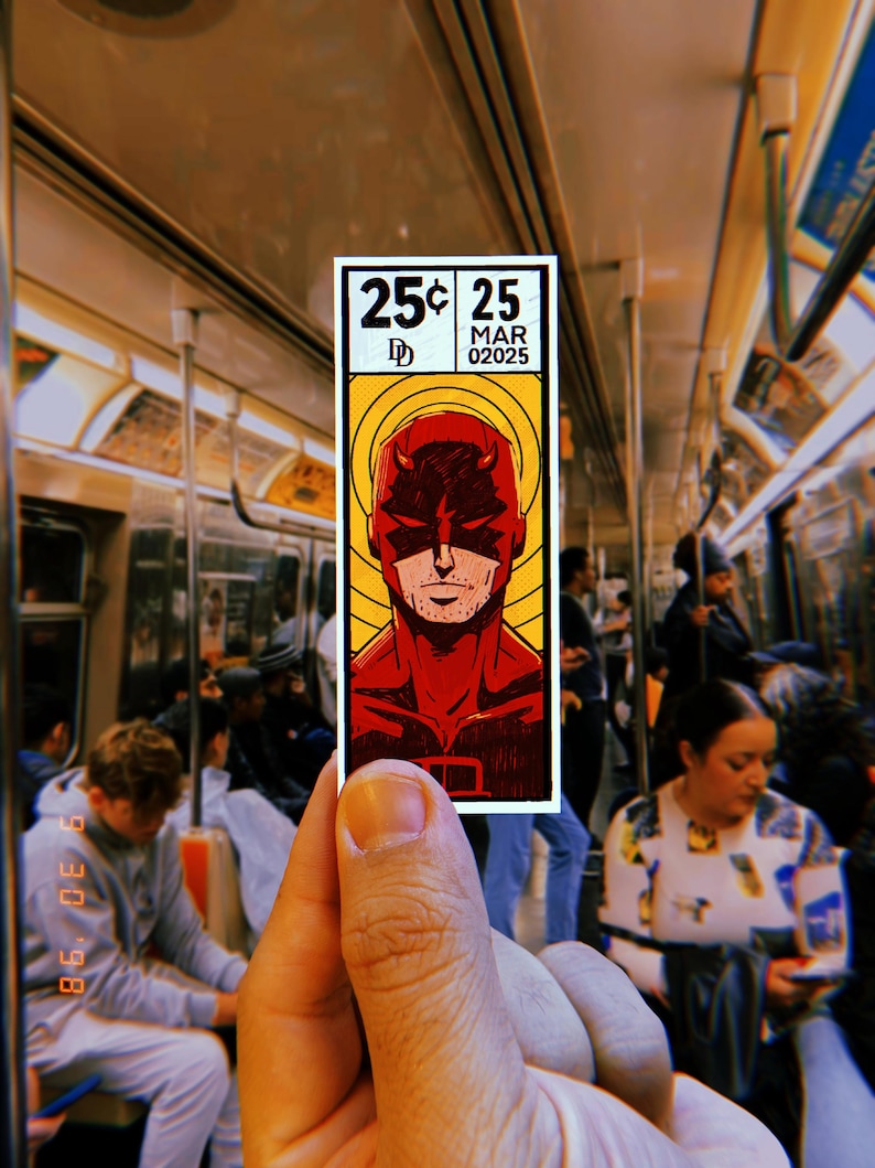 Peut inclure: Un ticket de m&eacute;tro de style bande dessin&eacute;e rouge et jaune avec le texte "25&cent; 25 MAR 02025" et une image de bande dessin&eacute;e de Daredevil, un super-h&eacute;ros en costume rouge et masque rouge.