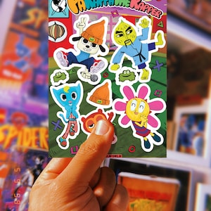 May include: A comic book cover featuring the characters from the video game "PaRappa the Rapper". The cover is green and features a yellow, orange, and blue color scheme. The title of the comic is "PaRappa the Rapper" and the comic is published by "BAESD WORLD COMICS".