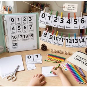 Puede incluir: Juego de manualidades educativo con tarjetas de números, un archivador y útiles de escritura. Incluye tarjetas con los números 0-20, un estuche y lápices de colores. El estuche dice "CREATIVE LEARNERS".