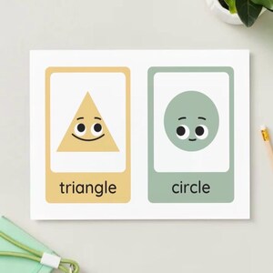 Puede incluir: Una tarjeta educativa rectangular con dos paneles verticales. El panel izquierdo es amarillo claro con un triángulo beige y el texto triangle. El panel derecho es verde salvia con un círculo verde salvia y el texto circle.